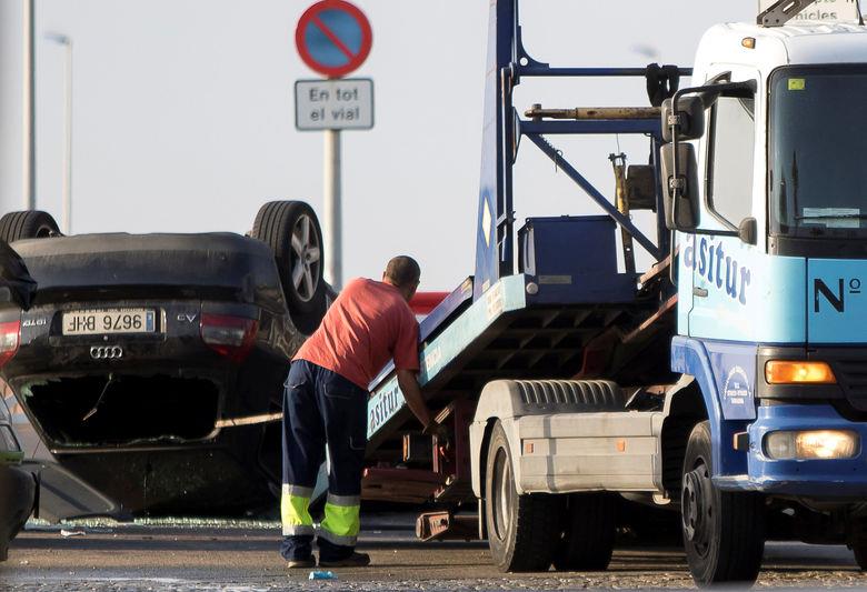 A worker loads a car on a tow truck where the police investigate the scene of an attack in Cambrils, south of Barcelona
