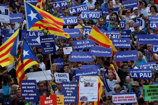 People hold placards and flag as they take part in a march of unity after the attacks last week, in Barcelona, Spain