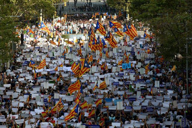People hold placards and flag as they take part in a march of unity after the attacks last week, in Barcelona, Spain