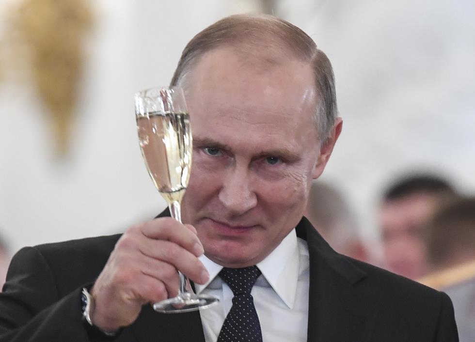 Russian President Vladimir Putin toasts with attendees after a state awards ceremony for military personnel who served in Syria, at the Kremlin in Moscow