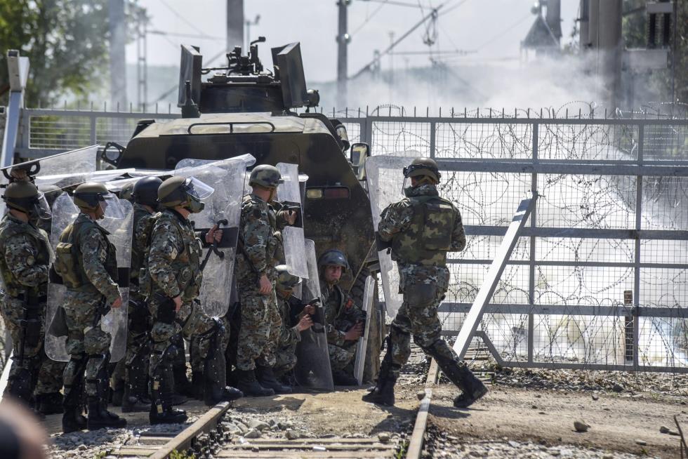 Macedonian police officers try to protect border fence attacked by the refugees and migrants from the Greek side of the border