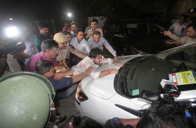 Supporter of Indias former Finance Minister Chidambaram tries to stop a vehicle carrying Chidambaram after he was arrested by CBI officials in New Delhi